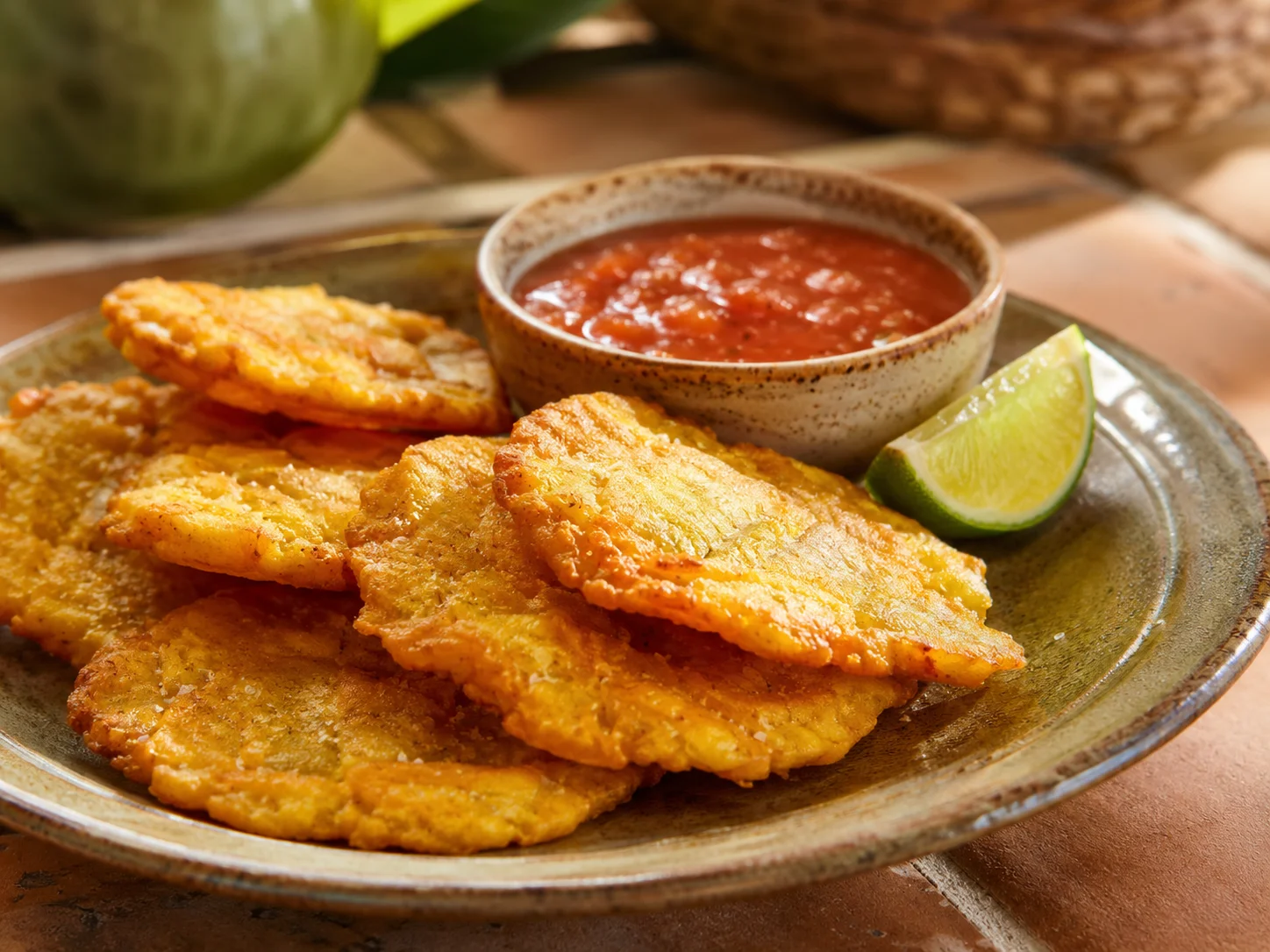 Colombian patacones with tomato dipping sauce and lime